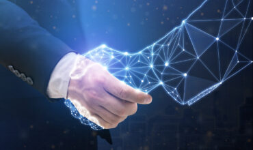 Businessperson shaking hand with digital partner over futuristic background.